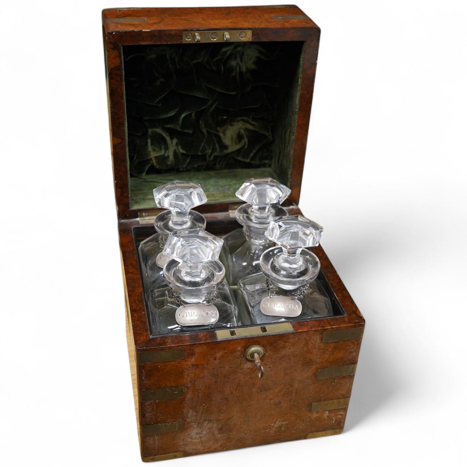 A Victorian burr walnut and brass bound four bottle decanter box, the four faceted square decanters with Victorian silver spirit labels, Bramah lock with key, 26cm high